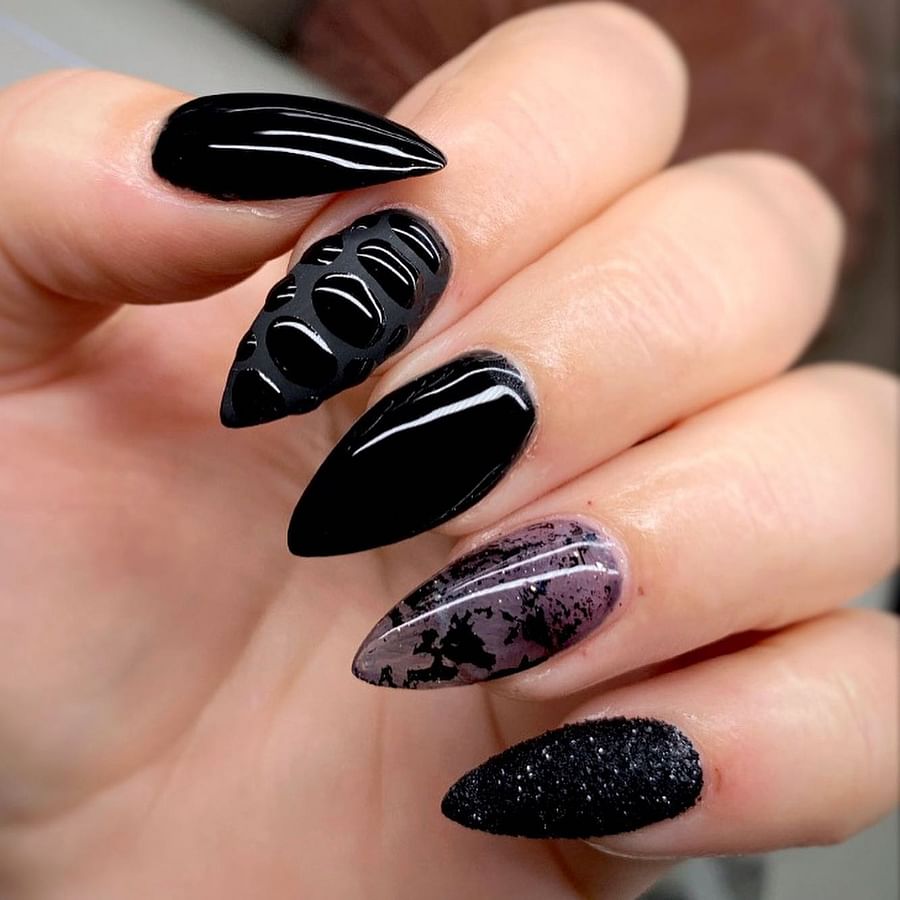 Close-up view of sophisticated black nail design on almond shaped nails